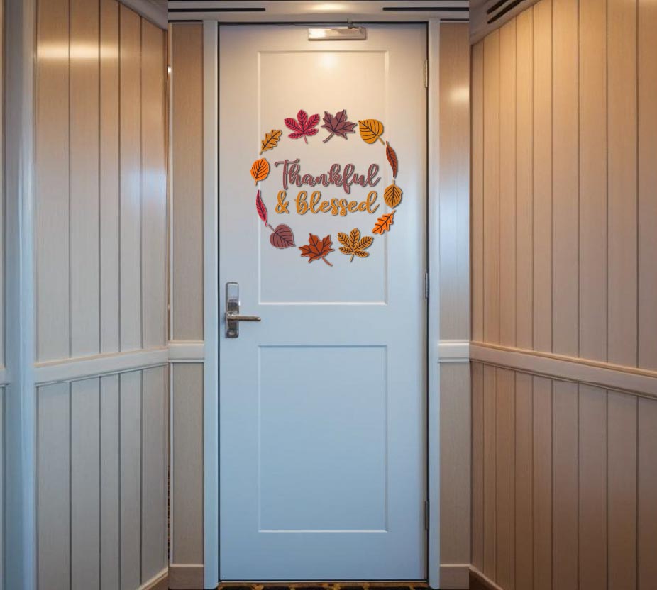 Fall leaf wreath magnet reading "Thankful & Blessed" in orange script on a white cruise cabin door